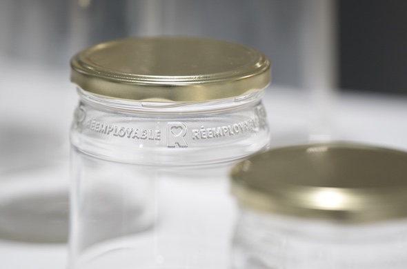 Pots en verre rÃ©employables avec couvercles mÃ©talliques, illustrant la stratÃ©gie de rÃ©emploi pour rÃ©duire lâimpact environnemental