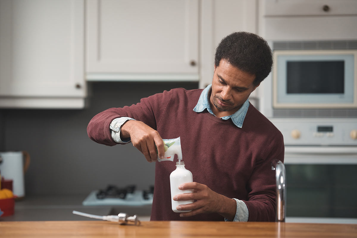 Personne ouvrant un contenant rÃ©utilisable dans une cuisine pour illustrer le potentiel du rÃ©emploi des emballages