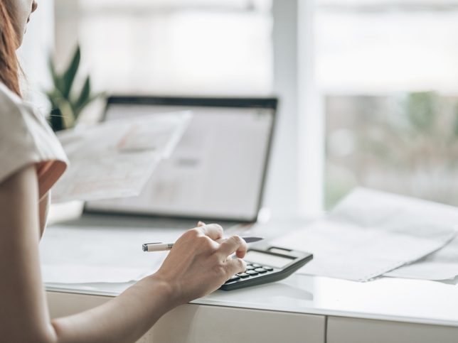 Personne utilisant un ordinateur et une calculatrice pour simuler une contribution REP